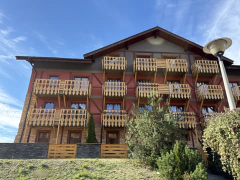 Four-storey building with red walls and carved wooden balconies